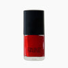 A bottle of Paint red nail polish by Paint Nail Lacquer against a white backdrop, this shade is a classic red
