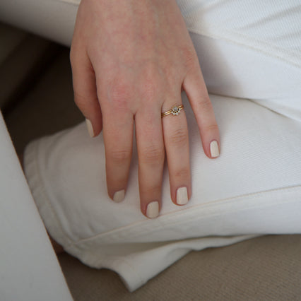 A female hand resting on white jeans wearing Coconut Cream nail polish a creamy white gloss shade
