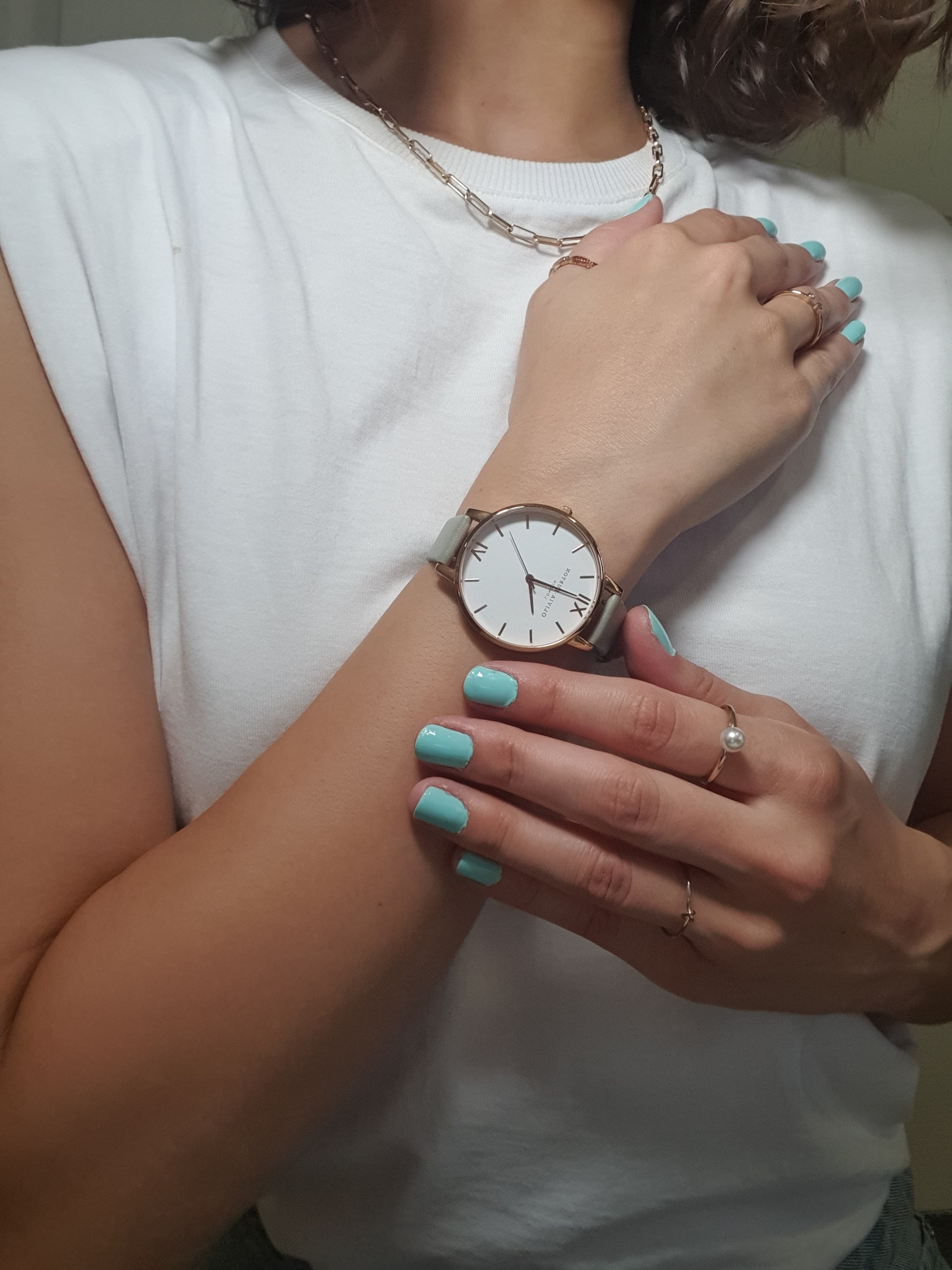 christina vlask showing olivia burton watch and wearing speamint cream nail polish a bright bold aquamarine shade 
