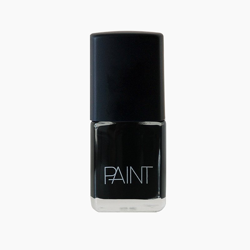 A bottle of Black Dog nail polish by Paint Nail Lacquer against a white backdrop, this shade is a classic midnight black colour 