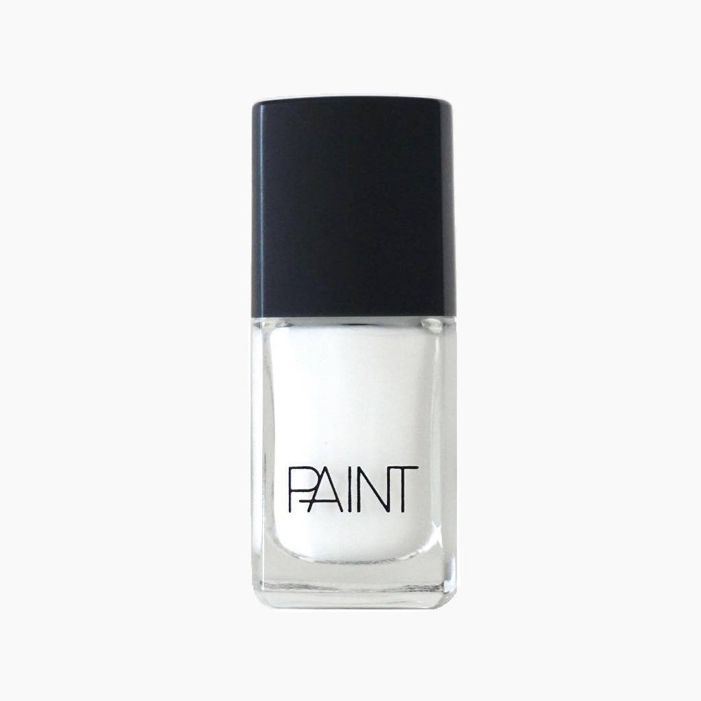 A bottle of Limed White Nail Polish by Paint Nail Lacquer against a white backdrop, this shade is a bold, pearly white colour