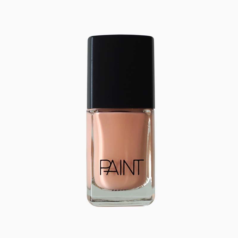 A bottle of Peach Club nail polish by Paint Nail Lacquer against a white backdrop, this shade is a light, creamy orange pink colour