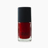 A bottle of Scarlet venom nail polish by Paint Nail Lacquer against a white backdrop, this shade is a dark red in colour