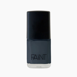 A bottle of Storm grey nail polish by Paint Nail Lacquer against a white backdrop, this shade is a dark blue with grey undertones.